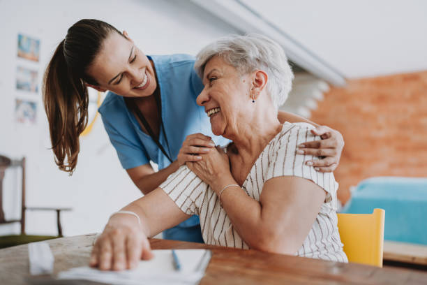 A carer embracing a smiling resident at a table