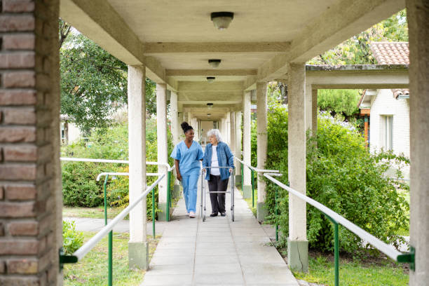 A carer walking with a resident along a covered garden walkway